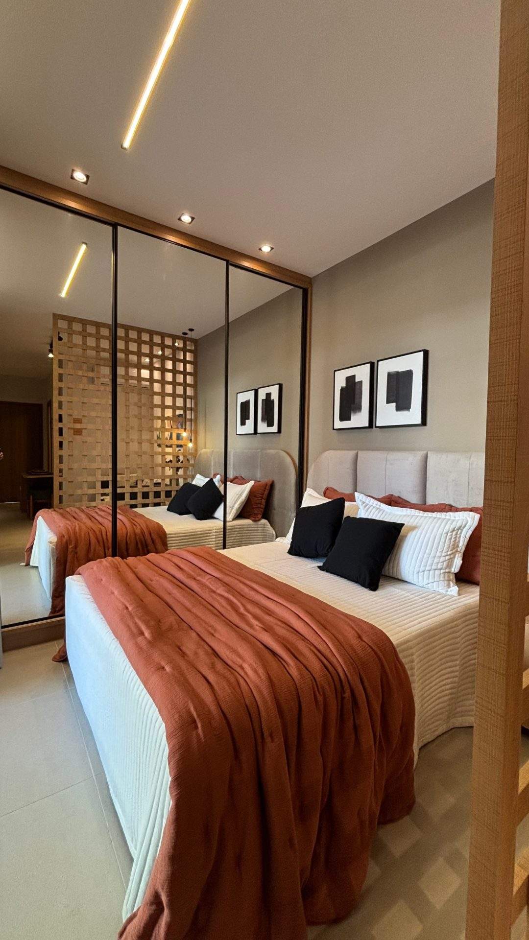 Quarto do apartamento decorado, com cabeceira estofada e luz natural